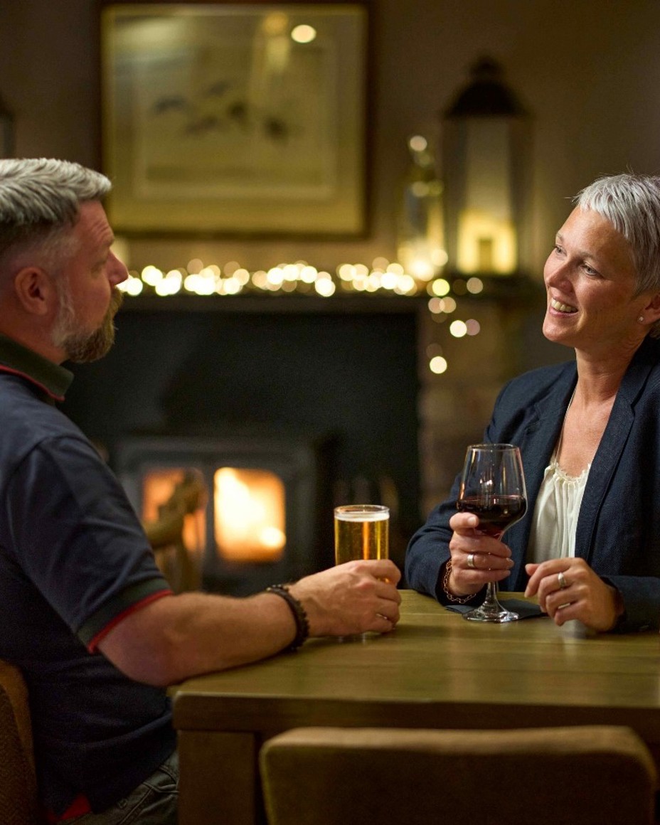 Couple enjoying drinks in front of the fire