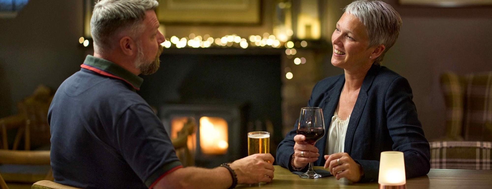 Couple enjoying drinks in front of the fire